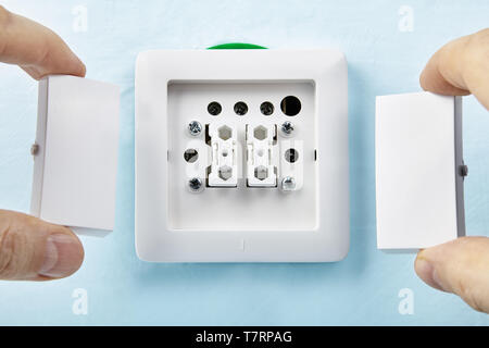 Putting new buttons on european standard push button by electrician, electric installation work. Stock Photo