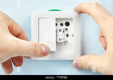 Electrician is making new light switch putting on new button, electric installation work. Stock Photo