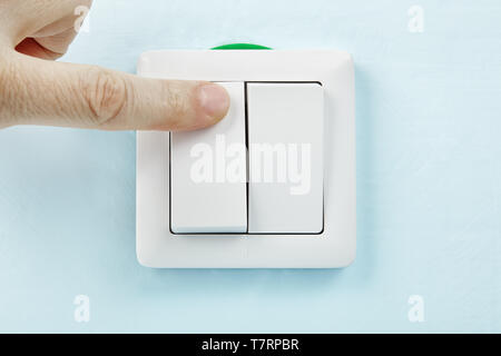 Worker is turning on or off new european standard light switch, electrical maintenance. Stock Photo