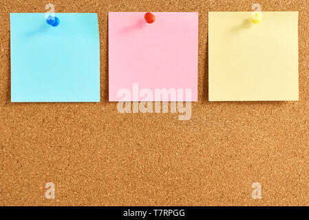 Cork board with pinned colored blank notes Stock Photo