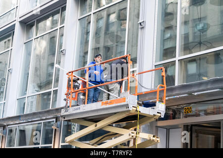 New York City, USA - April 6, 2018: Midtown Manhattan with people on scaffold construction in NYC working workers Stock Photo