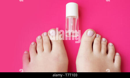 Pedicure with transparent nail polish on pink background. Healthy feet, health care Stock Photo