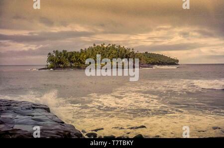 French Guiana. 10th Apr, 2000. A late afternoon view of the rocky islet of Devils Island (ÃŽle du Diable) from Ile Royale, one of the three islands (Royale, Saint-Joseph, and Diable) of the volcanic ÃŽles du Salut group off French Guiana, collectively called Devils Island (ÃŽle du Diable). Now a nature reserve, serving tourists and cruise ship passengers, visitors are not allowed on small Devils Island but tour the decaying old prison facilities on nearby Isle Royale. Credit: Arnold Drapkin/ZUMA Wire/Alamy Live News Stock Photo