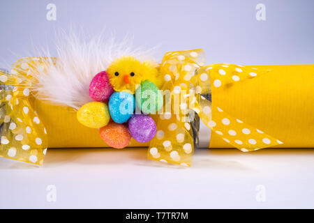 Easter Chick and eggs on an Easter Cracker or otherwise known as a Bon Bon. A traditional cracker consists of a cardboard tube wrapped in a brightly d Stock Photo