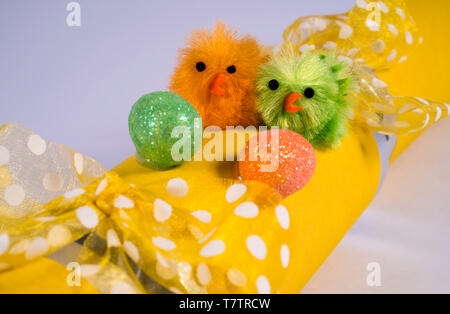 Easter Chicks on an Easter Cracker or otherwise known as a Bon Bon. A traditional cracker consists of a cardboard tube wrapped in a brightly decorated Stock Photo