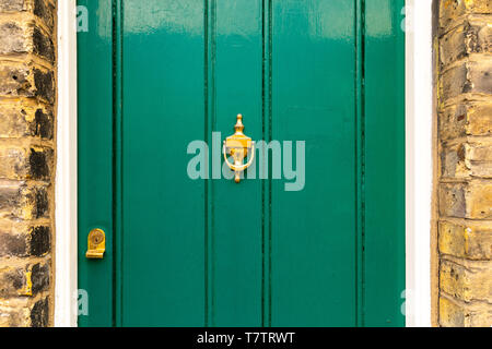 Background of vintage green painted door and knocker vignette look made of old fashioned vintage brass metal Stock Photo