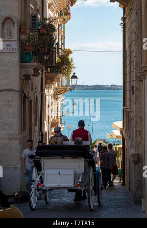 A view down the Via Picherali towards the seafront on Ortygia Island, Syracuse, Sicily. Stock Photo