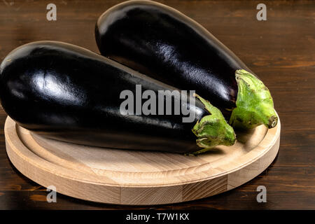 fresh eggplants isolated on  wood cutting board, white background Stock Photo