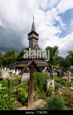 Ieud Hill Church and its graveyard, the oldest wood church in Maramures, Romania under dramatic sky. The Church belongs to a collection of Wooden Chur Stock Photo