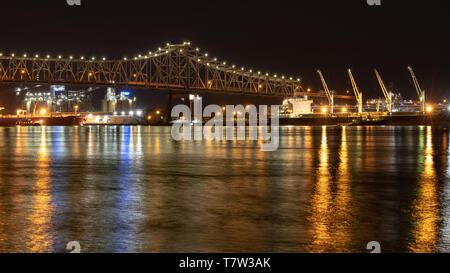 River bridge at night with cars passing over, and boats in the water Stock Photo