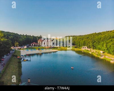 aerial view of resort near lake forest around. people on boats and catamarans Stock Photo