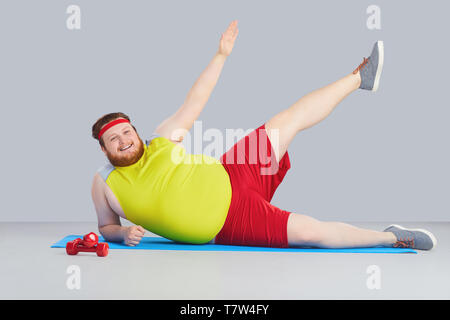 Funny yoga. Fat man doing yoga exercises in the room Stock Photo