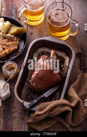 Baked Pork knuckle with beer and cauliflower in roast pan. Stock Photo