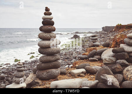 Color toned picture of a stone stack on a beach, balance and harmony concept, selective focus. Stock Photo