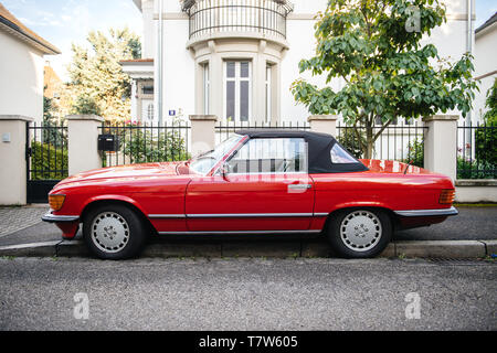 Strasbourg, France - May 19, 2017: Side view of luxury vintage red convertible cabriolet Mercedes-Benz 300 Sl parked in front of French luxury house in calm neighborhood Stock Photo