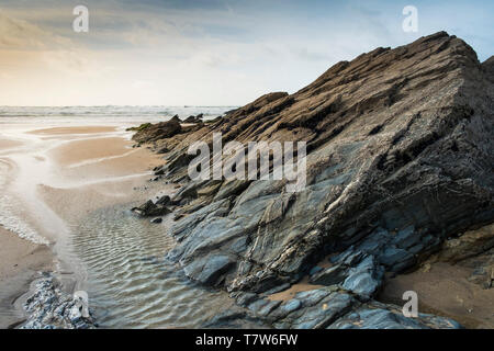 Rocks exposed at low tide on Fistral Beach in Newquay in Cornwall. Stock Photo