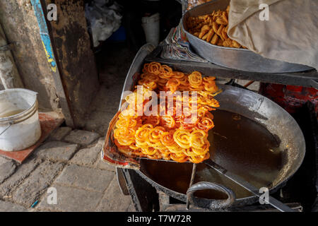 Street scene, Mahipalpur district, a suburb near Delhi Airport in New Delhi, capital of India: Indian sweet, crispy golden deep fried jalebi Stock Photo