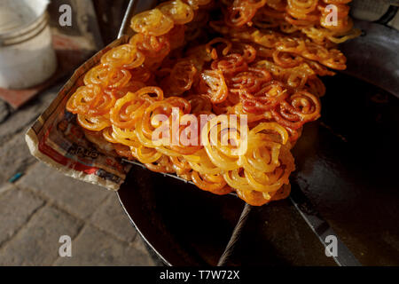 Street scene, Mahipalpur district, a suburb near Delhi Airport in New Delhi, capital of India: Indian sweet, crispy golden deep fried jalebi Stock Photo