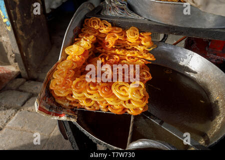 Street scene, Mahipalpur district, a suburb near Delhi Airport in New Delhi, capital of India: Indian sweet, crispy golden deep fried jalebi Stock Photo