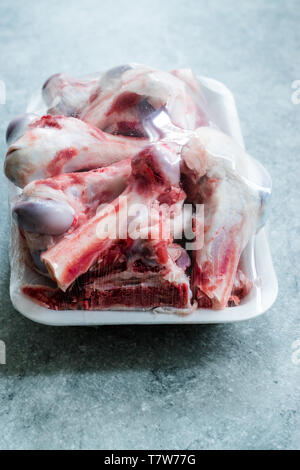 Raw Lamb Bone Marrow in Plastic Container Package with Stretch Film Foil. Ready to Boil. Stock Photo
