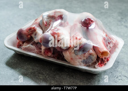 Raw Lamb Bone Marrow in Plastic Container Package with Stretch Film Foil. Ready to Boil. Stock Photo