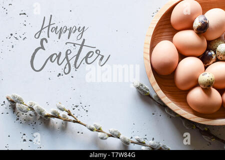 Eggs in wooden bowl with willow catkin twigs. Copy space, Easter theme. Stock Photo