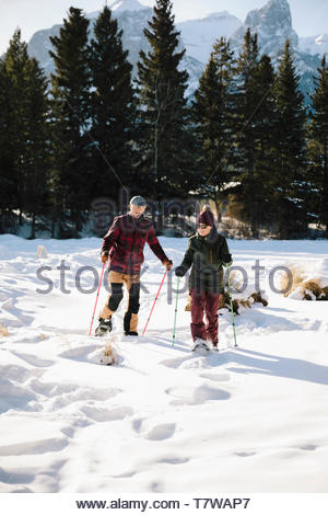 Senior couple snowshoeing in snowy field