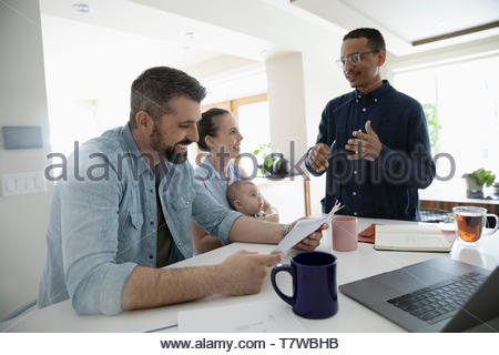 Financial planner meeting with couple in kitchen