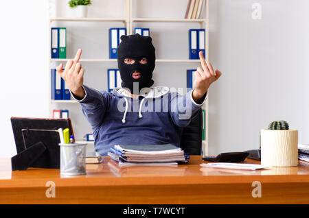 Male thief in balaclava in the office Stock Photo