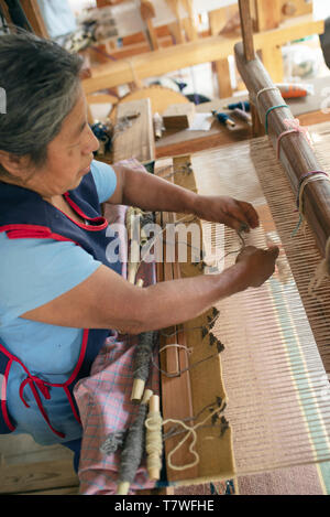 Zapotec woman weaving a rug on a pedal loom. Teotitlan del Valle, Oaxaca, Mexico. Apr 2019 Stock Photo