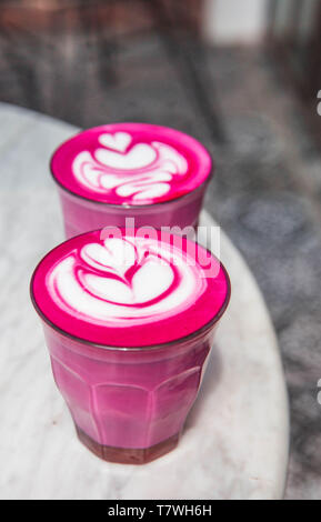 Two colorful trendy pink beetroot latte on white marbel background. Stock Photo