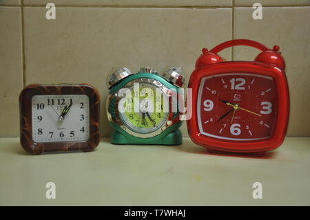 There are three different clocks on the table Stock Photo