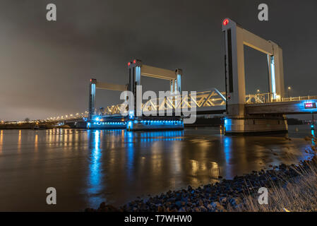 ROTTERDAM, 21 March 2019 - View of the Botlek bridge at the entrance of Rotterdam city by boats reflection on the calm water against a chemical indust Stock Photo