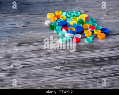 Image of colorful plastic caps on a wooden table with blurry background Stock Photo