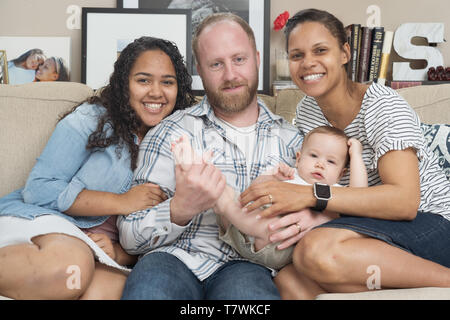 family of  4 in their home in north Philadelphia, 6 month old baby, 15 year old sister. Stock Photo