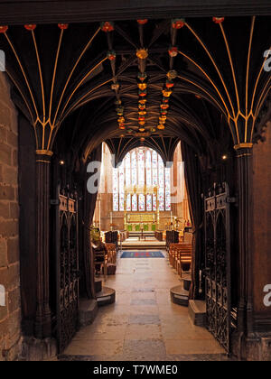 view of nave of Carlisle cathedral towards altar & East window through wood panelled passage with intricate gilt vaulted ceiling, Cumbria, England Stock Photo