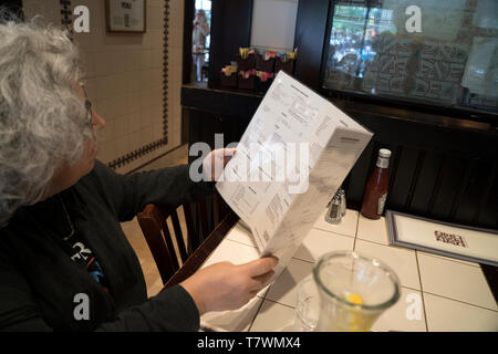 Reading the menu at the 2nd Avenue Deli on the Upper East Side of Manhattan. May 8, 2019 Stock Photo