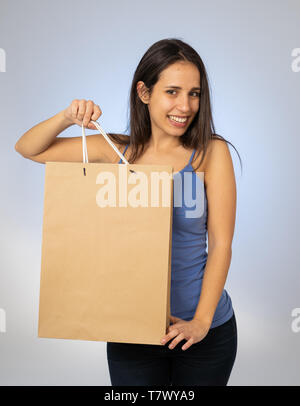 Young Pretty latin woman showing and holding shopping bag with empty copy space ready for advertisement In Sales Special gifts Recycling paper bags Fa Stock Photo