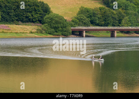 Anglers out on Wimbleball lake with Bessom Bridge in the background. Part of the Exmoor National Park in Somerset, England, UK Stock Photo