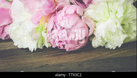 Peony border. Vintage image. Pink and white peonies on wooden background. Close up of fresh blooming flowers. Space for text. Stock Photo