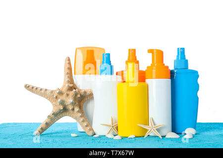 Different sunscreen sprays with starfishes and seashells on color table isolated on white background. Safe tan Stock Photo