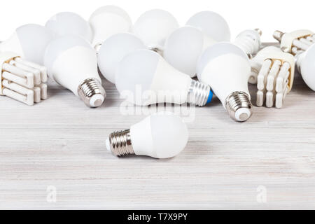 white LED bulb lights and fluorescent tube lamps on gray wooden board and white background Stock Photo