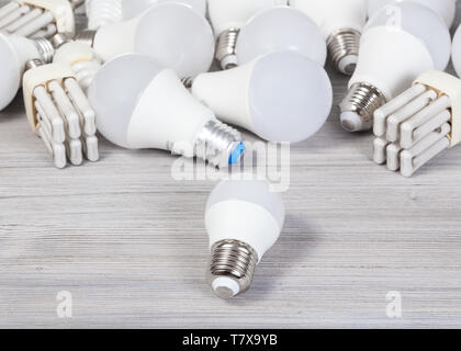 still life with white LED bulb lights and energy-saving lamps on gray wooden board Stock Photo