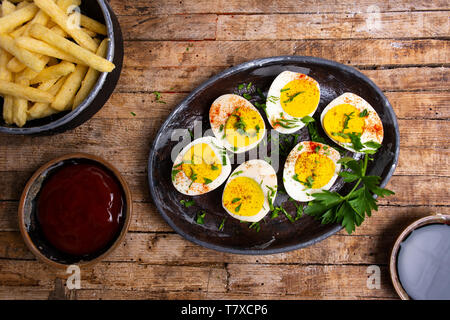 Boiled eggs and french fires on a table top view Stock Photo