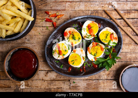 Boiled eggs and french fires on a table top view Stock Photo