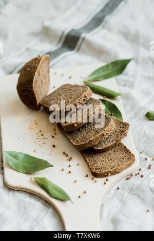 Freshly baked sliced bread on a wooden Board on dark grey fabric with seed Stock Photo