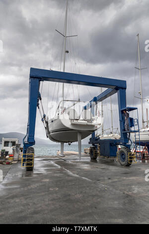 Tivat, Montenegro, April 29th 2019: Sailing yacht transporting in the sea after repair by marina mobile crane. Stock Photo