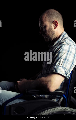 Portrait of a man sitting on a wheelchair for disabled people, sad expression. Stock Photo