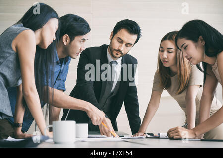 Group of multi-ethnic business partners discussing ideas in meeting room at office. Business people meeting corporate communication teamwork concept. Stock Photo