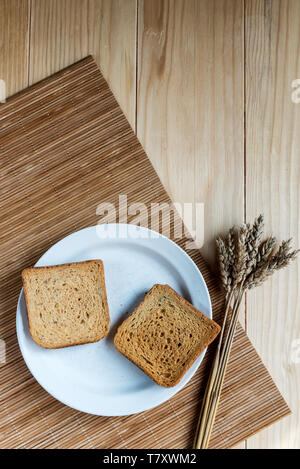 Two Slices of Toast Bread and Ear of Wheat on a Wooden Table Setup Stock Photo